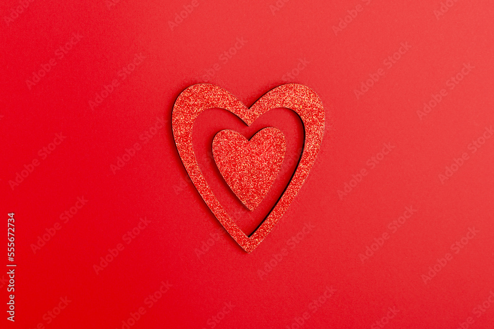 Red shiny hearts on a red background. The concept of Valentine's day, love, dating and wedding. Monochrome, minimalism