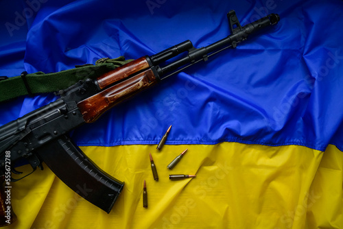 Автоматична нарізна зброя разом із набоями на прапрорі України, як символ свободи та боротьби за демократію.