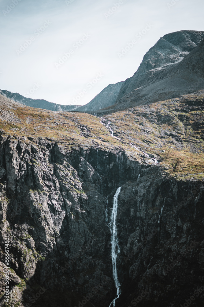 Waterfall with mountains in moody autumn Norway.