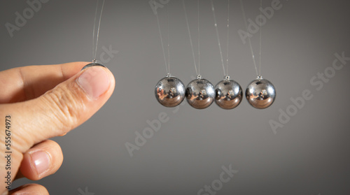 Male hand showing Newton's cradle balls.