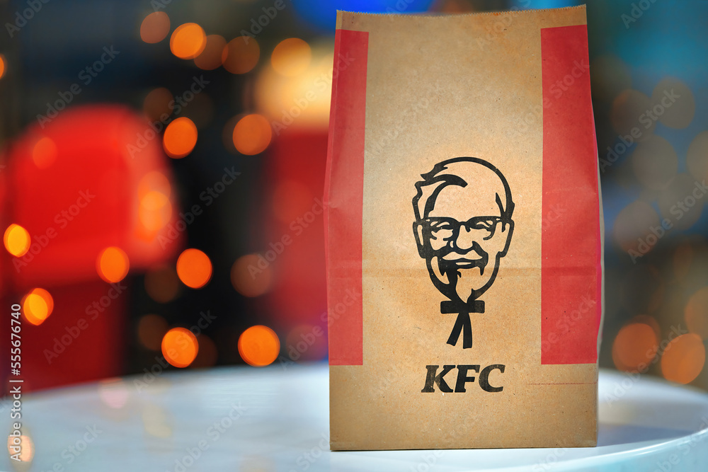 Minsk, Belarus. Dec 2022. KFC paper bag, Kentucky Fried Chicken bag against  Christmas lights background. KFC paper package and festive Christmas  garlands in bokeh. Stock Photo | Adobe Stock