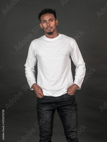 A man with white blank shirt doing a pose with black background