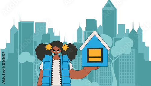 Concept Investment in real estate. Girl realtor holds a house in her hands.