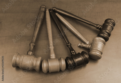 Many wooden judge gavels on table, one judge gavel broken. Symbol corruption and bribes in legal system.