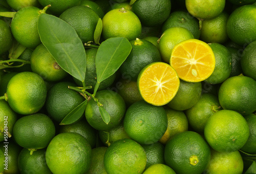 Photos Fresh green limes background. Many ripe calamansi limes close up.