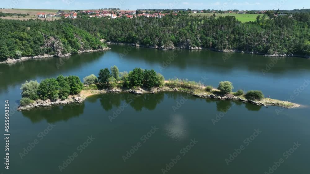 An island on a flooded dam in the Czech Republic, in the highlands, with water surface and forest around An island on a flooded dam in the Czech Republic, in the highlands, with water surface and forest around