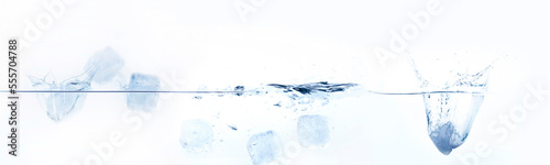 Cubetti di ghiaccio che cadono in spruzzi d'acqua isolati su sfondo bianco.
