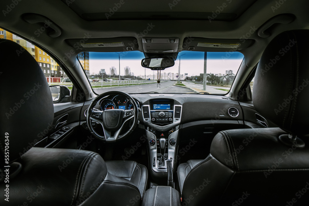 The interior of a car with a black leather interior and an automatic gearbox