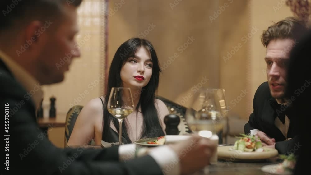 friendly dinner in restaurant, men and their wives sitting at table and talking, classmates meeting friendly dinner in restaurant, men and their wives sitting at table and talking, classmates meeting