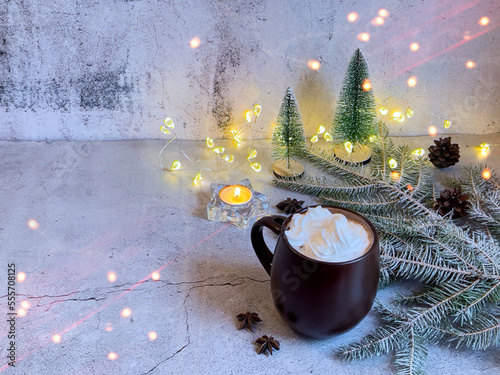 Hot chocolate with whipped cream on a table decorated for Christmas and New Year on a gray background. A postcard with copy space.