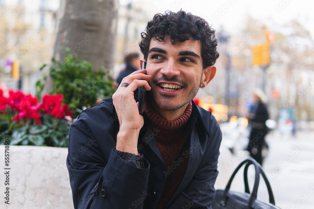 Smiling ethnic guy talking on smartphone on street Smiling ethnic guy talking on smartphone on street