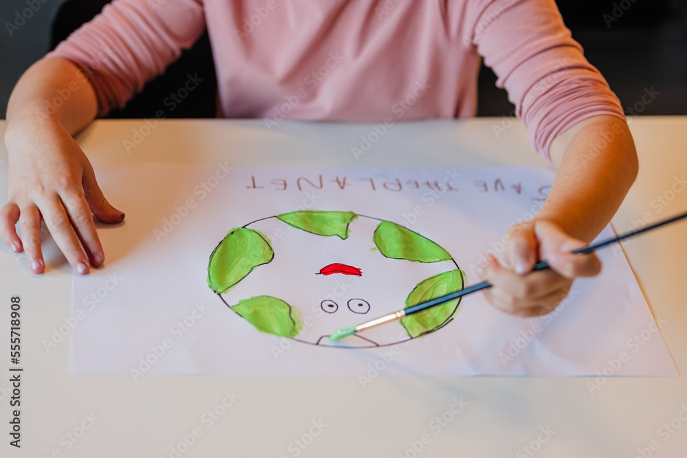 Girl painting environmental banner on paper Girl painting environmental banner on paper