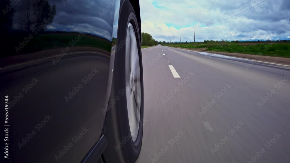 Driving a car on a country road, Wheel spinning in sunset, Low camera position 