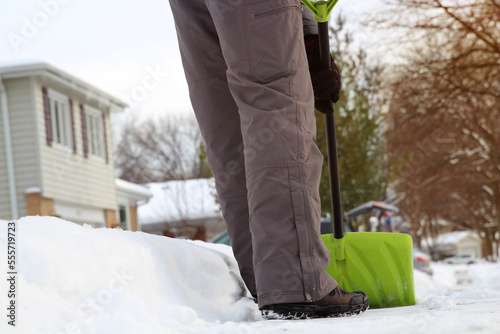 Man  is  shoveling and removing snow in front of his house in the suburb after a snowstorm. photo