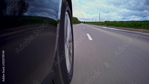 Driving a car on a country road, Wheel spinning in sunset, Low camera position 