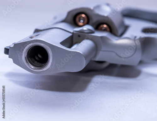 The muzzle of a 454 casull snub nose revolver loaded with hollow point bullets on a white background