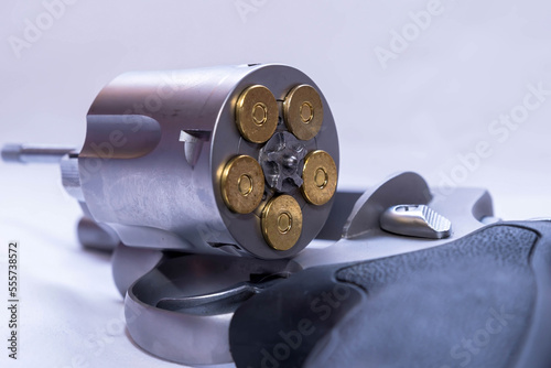 A stainless steel, snub nose 454 casull revolver, with the cylinder opened showing that it's loaded on a white background photo