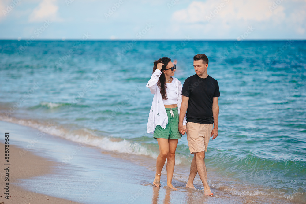 Young couple on the beach vacation walking