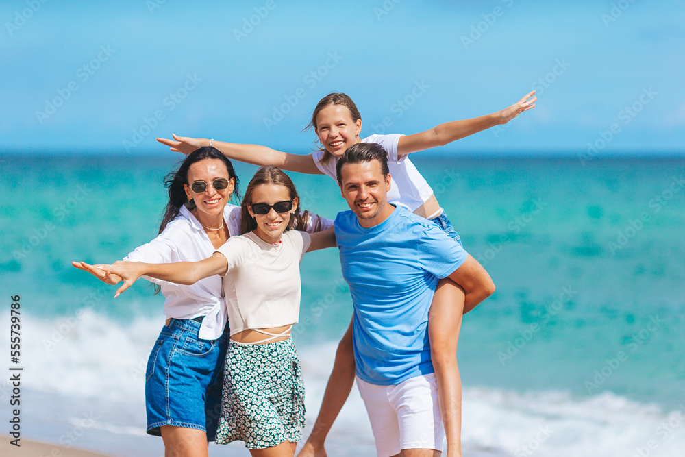 Family of four have fun together on beach vacation in Florida