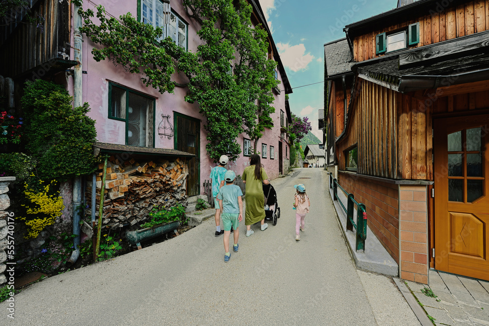 Mother with baby carriage and children walking in Hallstatt, Austria.