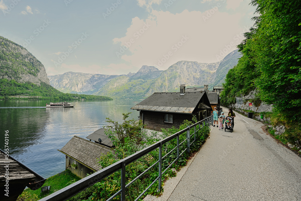 Mother with baby carriage and children walking in Hallstatt, Austria. Mother with baby carriage and children walking in Hallstatt, Austria.