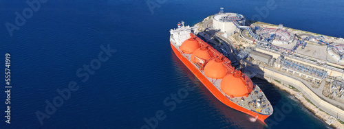 Obraz na płótnie Aerial drone ultra wide panoramic photo of LNG (Liquified Natural Gas) tanker anchored in small gas terminal island with tanks for storage w salonie