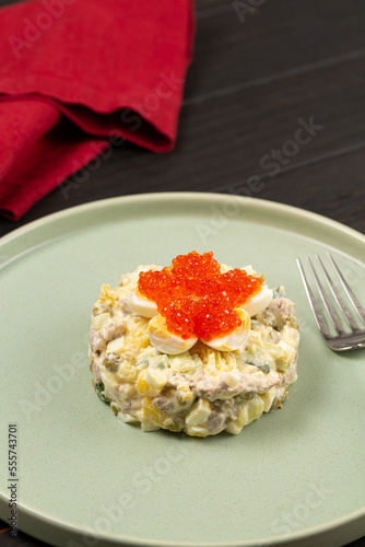 Russian winter salad with quail eggs and red caviar