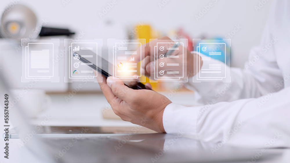 Paperless workplace ideas, e-signing, electronic signature, document management. A businessman signs an electronic document on a digital document on a virtual screen Paperless workplace ideas, e-signing, electronic signature, document management. A businessman signs an electronic document on a digital document on a virtual screen