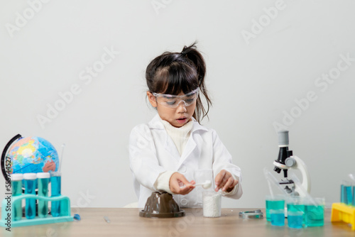 education, science, chemistry and children concept - kids or students with test tube making experiment at school laboratory