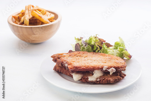 steak filled cheese and ham (san jacobo, librito) with salad and potatoes chips photo