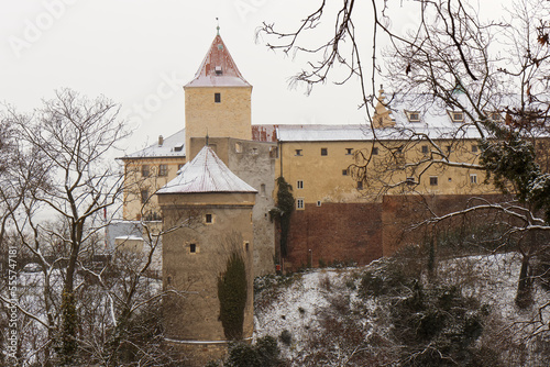 Deer Moat and Daliborka tower in foreground with snow-covered roofs of Prague Castle in winter, no people. photo