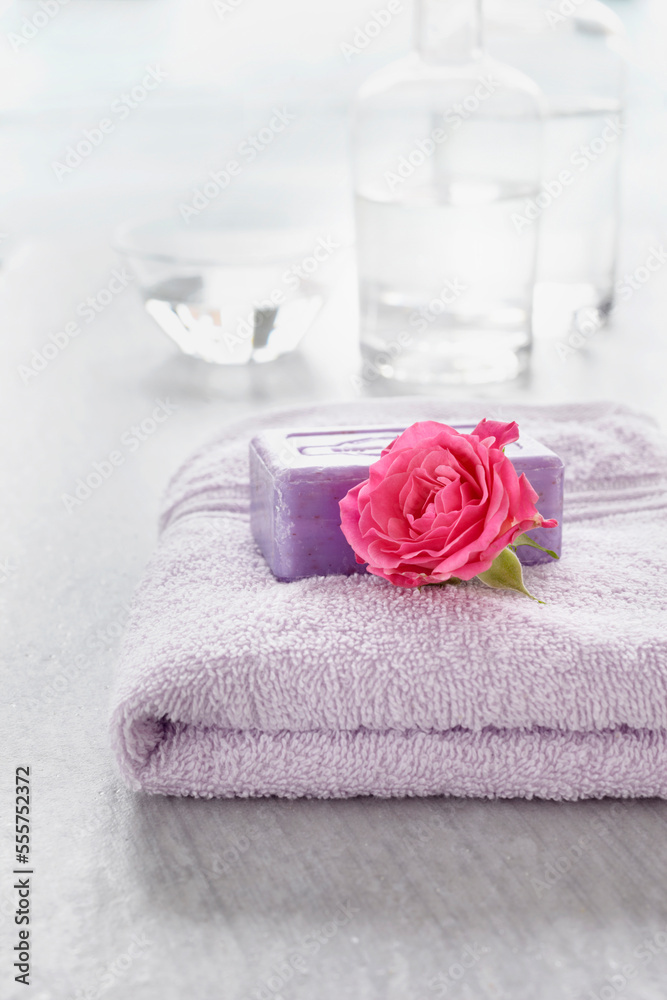 Rose and bath products like towel, soap and bottles of essential oil for aromatherapy and wellness Rose and bath products like towel, soap and bottles of essential oil for aromatherapy and wellness