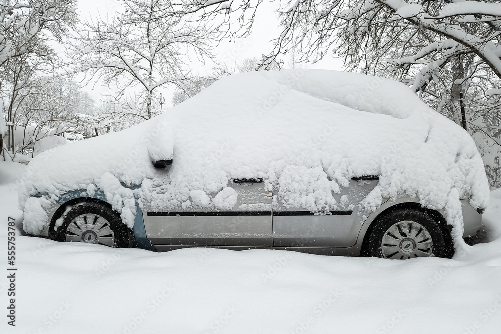 The car in the parking lot is completely covered with snow. Problems after heavy snowfall. The car in the parking lot is completely covered with snow. Problems after heavy snowfall.