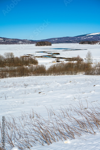 Wallpaper Mural Winter landscape with a watch post and tributary River entering the frozen lake with with lake island and hills in the background background. Frozen Lake on a cold winter day. Torontodigital.ca