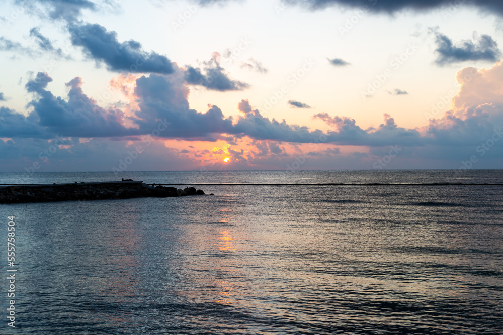 vue sur la mer lors d'un lever de soleil avec des nuages dans le ciel