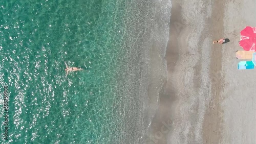 Aerial footage of the Spanish Calnegre beach in the coast of Murcia showing a drone  view of a beautiful sandy beach and people sunbathing and swimming. photo