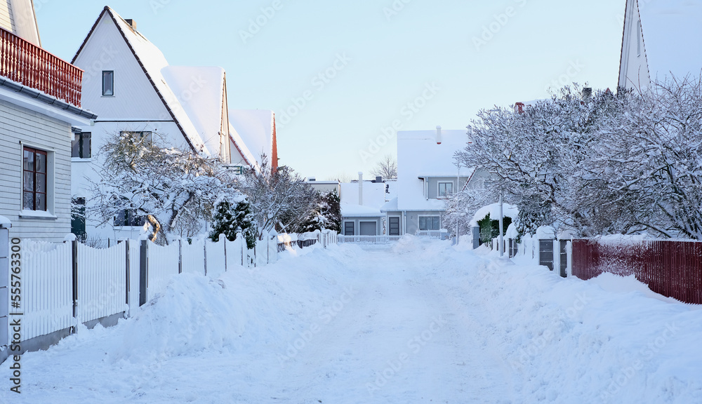 Winter fairy-tale landscape on the street with houses with a triangular roof and roads covered with a lot of snow Winter fairy-tale landscape on the street with houses with a triangular roof and roads covered with a lot of snow