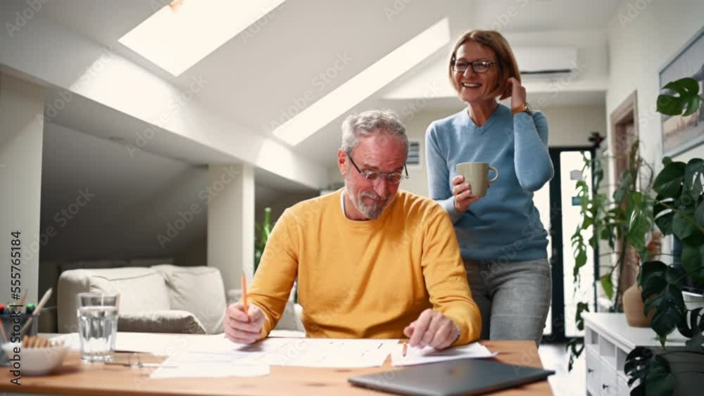 Mature senior couple working together on a blueprints of their new home. Mature senior couple working together on a blueprints of their new home.