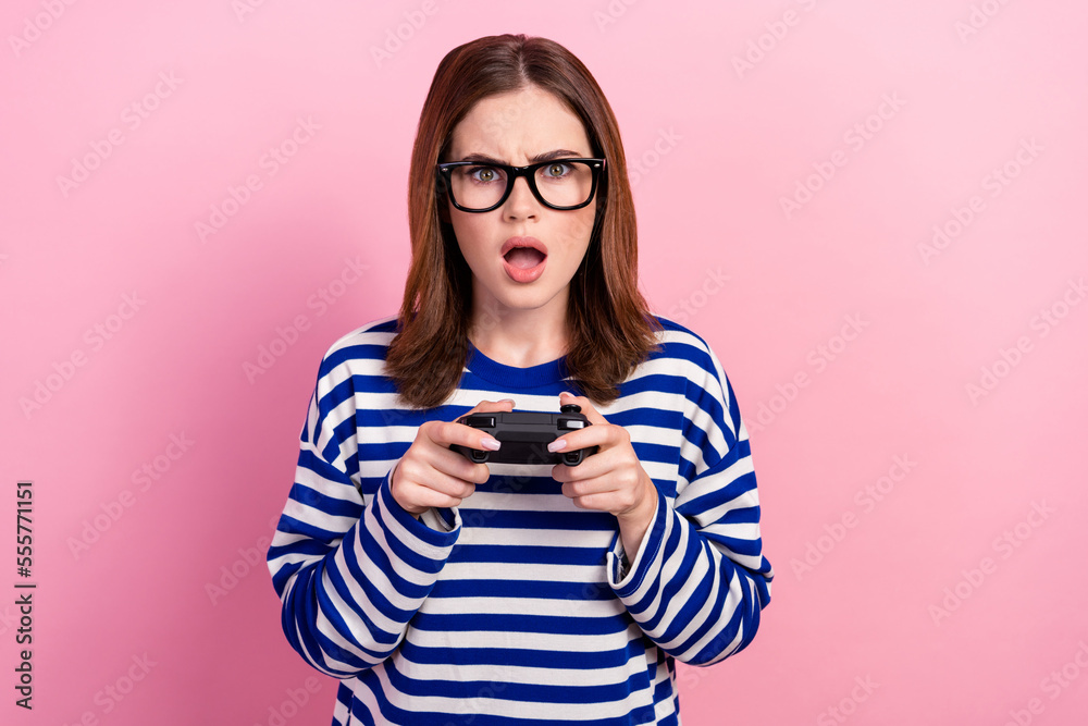 Photo of astonished impressed worried outraged lady hold playstation game over isolated on pink color background Photo of astonished impressed worried outraged lady hold playstation game over isolated on pink color background
