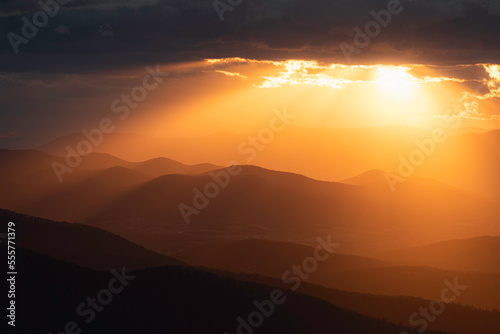 Golden crepuscular rays spill out and illuminate the mountains and valleys of Shenandoah National Park.