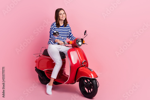 Foto Full size photo of charming cheerful girl sit drive moped enjoy weekend isolated