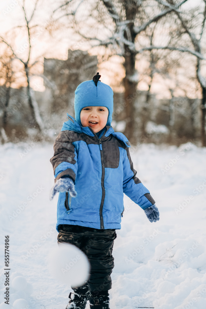 The kid plays with snow in the park in winter. Active winter walks with children. The kid plays with snow in the park in winter. Active winter walks with children.