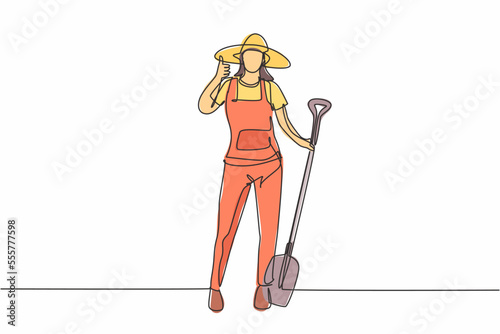 Single one line drawing of female farmer stood with a thumbs-up gesture, wearing a straw hat and carrying a shovel to plant crops on farmland. Continuous line draw design graphic vector illustration.