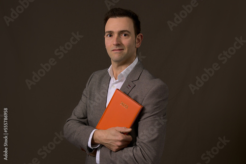 Professional Elegant formal CEO of a company holding a 2023 orange agenda. Concept new year resolution in business