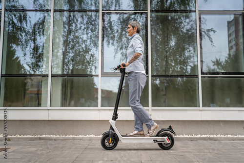 One woman mature senior adult female with eco electric kick scooter