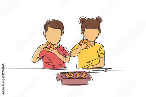 Continuous one line drawing two boy and girl having donuts meal with hand around table. Happy and enjoy breakfast at home. Tasty and healthy food. Single line draw design vector graphic illustration