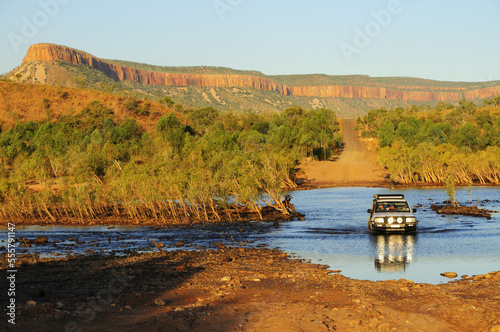 SUV Crossing Pentecost River with Cockburn Ranges in Background, Gibb River Road, Kimberley, Western Australia, Australia photo
