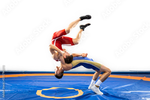 The concept of fair wrestling. Two greco-roman wrestlers in red and blue uniform wrestling on a wrestling carpet