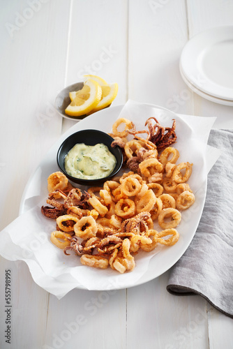 Plate of deep fried calamari with tarter sauce and lemon photo