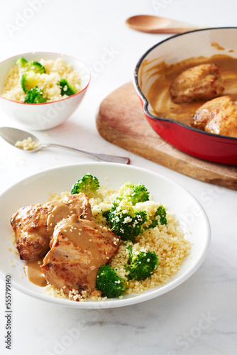 Chicken thighs with mustard sauce served with couscous and broccoli photo